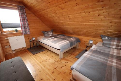 a bedroom with a bed in a log cabin at Feriendorf Blauvogel Blauvogel 001 in Hasselfelde