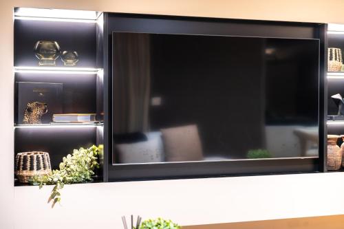 a flat screen tv sitting on top of a shelf at Luxury Beachfront Penthouse, Blouberg- 3 Bedroom in Bloubergstrand