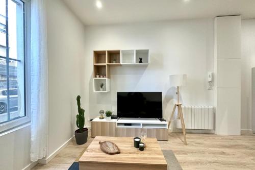 un salon avec une télévision et une table dans l'établissement Studio NEUF proche METRO, à Villeurbanne