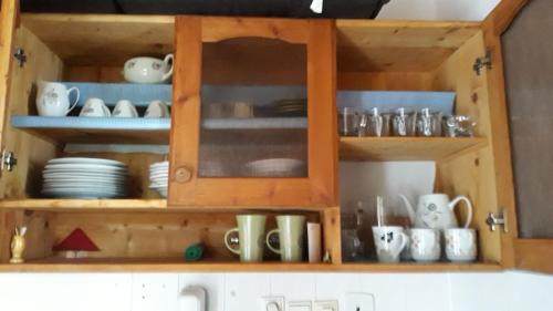 a wooden cabinet with cups and dishes in it at Apartmán Margarétka in Liptovský Trnovec