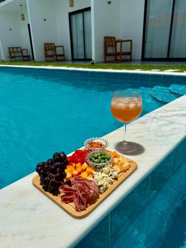 a tray of food and a drink next to a pool at Yahweh Hotel in São Miguel do Gostoso
