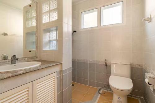 a white bathroom with a toilet and a sink at Top family house in peaceful area with lake view 3BR 15 mins to city in Chiang Mai