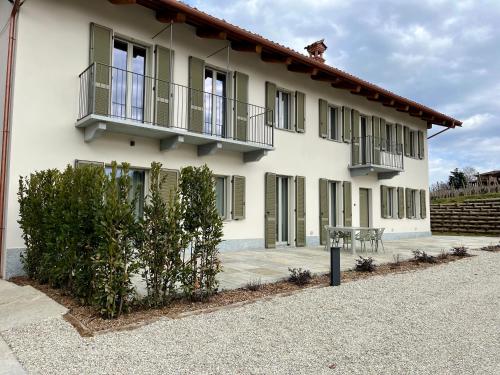 a white building with a balcony and a table at Cascina Luscai in Novello