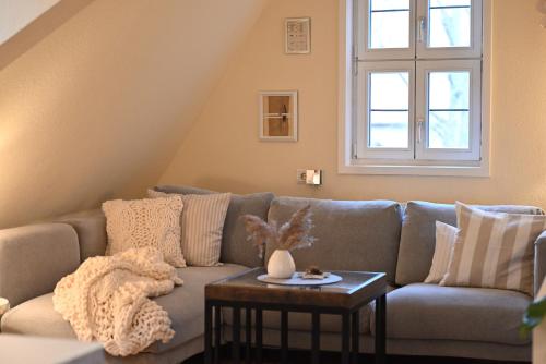 a living room with a couch and a table at TÜRMERSTUBE - Scandi Style - in der historischen Hinterburg Schlitz - nahe Fulda in Schlitz