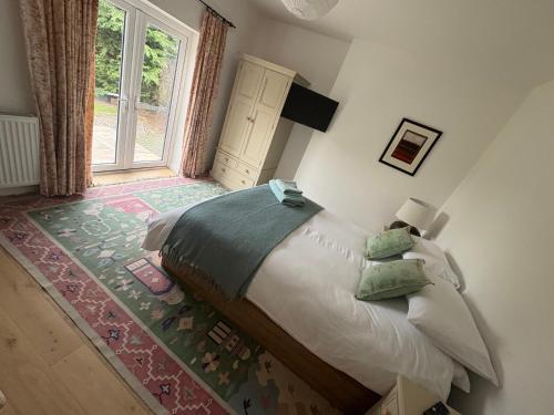 una camera da letto con un letto e una grande finestra di Mains of Greenlaw Cottage a Castle Douglas