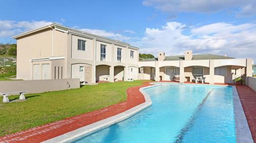 a house with a swimming pool in front of a building at Breezy Sunny Apartment in Cape Town