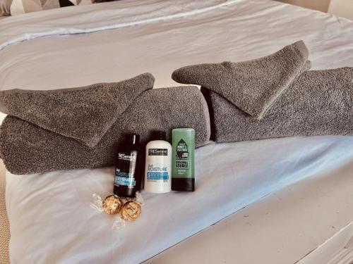 ein Bett mit drei Flaschen Duftstoffen und Kissen darauf in der Unterkunft East Durham Terraced Home in Easington