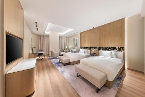 a hotel room with two beds and a flat screen tv at Braira Hafar Al-Batin in Hafr Al Baten