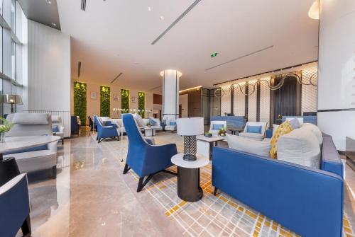 a waiting room with blue chairs and tables at Braira Hafar Al-Batin in Hafr Al Baten