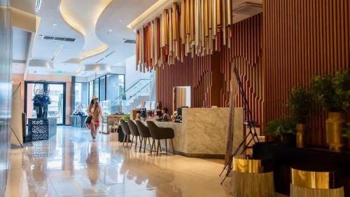 a woman walking through a lobby of a building at The Astra Luxury Condo near old town in Chiang Mai