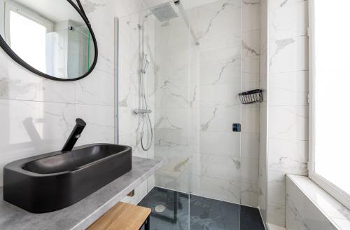 La salle de bains est pourvue d'un lavabo noir et d'une douche. dans l'établissement AC & Duplex Close to Eiffel Tower - 20 min Away, à Paris