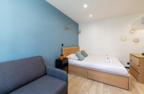 une petite chambre avec un lit et un canapé dans l'établissement AC & Duplex Close to Eiffel Tower - 20 min Away, à Paris