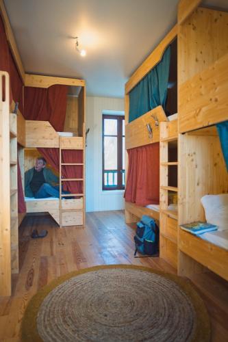 Cette chambre comprend 3 lits superposés et un grand tapis. dans l'établissement La Ruche - l'auberge qui relie, à Aouste-sur-Sye
