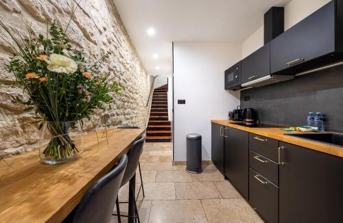 une cuisine avec un vase de fleurs sur un comptoir dans l'établissement AC & Duplex Close to Eiffel Tower - 20 min Away, à Paris