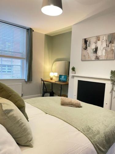 a bedroom with a bed with a fireplace and a desk at Brand New city Centre Flat, WiFi, Free Private off-site parking in Nottingham