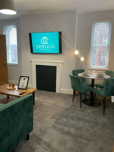 a waiting room with a table and chairs and a tv at Brand New city Centre Flat, WiFi, Free Private off-site parking in Nottingham