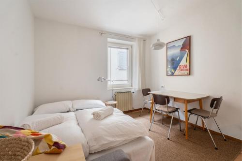 a bedroom with a bed and a table with chairs at Casa Claudia, stylish & spacious in Nago-Torbole