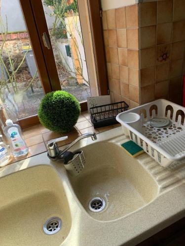 - un évier de cuisine avec un étendoir à vaisselle à côté d'une fenêtre dans l'établissement Maison, à Néris-les-Bains
