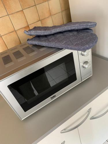 - un four micro-ondes sur un comptoir avec 2 serviettes dans l'établissement Maison, à Néris-les-Bains