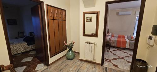 a hallway with a vase of flowers in a room at Casa Catena in Francavilla di Sicilia