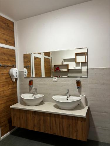 a bathroom with two sinks and a mirror at Hotel okriba in Tqibuli