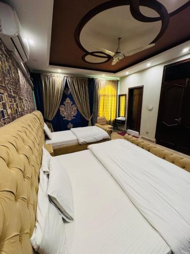 a bedroom with two beds and a ceiling at MadCrew Guest House in Islamabad