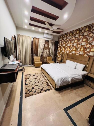 a bedroom with a bed and a couch and a television at MadCrew Guest House in Islamabad