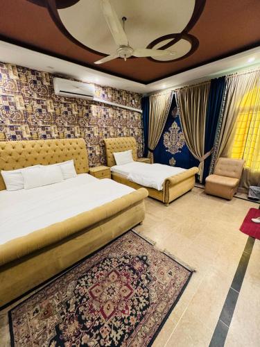 a bedroom with two beds and a couch at MadCrew Guest House in Islamabad