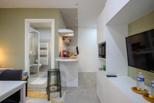 un salon avec une télévision et une cuisine dans l'établissement Le Jules, à Montbéliard