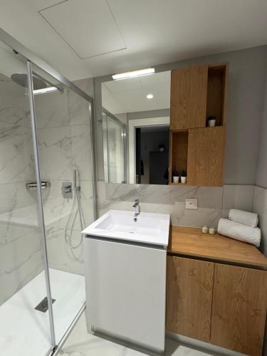 a bathroom with a white sink and a shower at City Pop 2Night Zürich City - Self check-in in Zürich