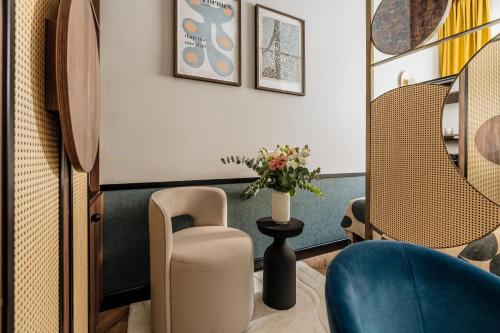 a waiting room with a chair and a vase of flowers at Colette - LoftAffair Collection in Warsaw