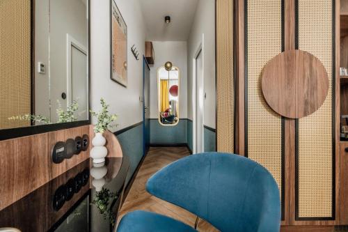 a room with a blue chair and a hallway at Colette - LoftAffair Collection in Warsaw