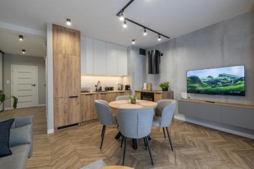 a kitchen and dining room with a table and chairs at VIP Apartamenty Borowa in Rzeszów