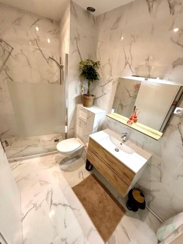 une salle de bain blanche avec un lavabo et des toilettes dans l'établissement L'Échappée de Nice Riviera I Centre-ville I Climatisé I Proche Gare et Plage I Idéal Couple et Famille, à Nice