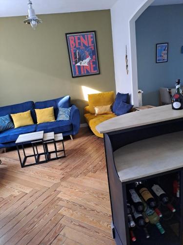 - un salon avec un canapé bleu et des oreillers jaunes dans l'établissement Le Chant des Bénédictins, à Fécamp