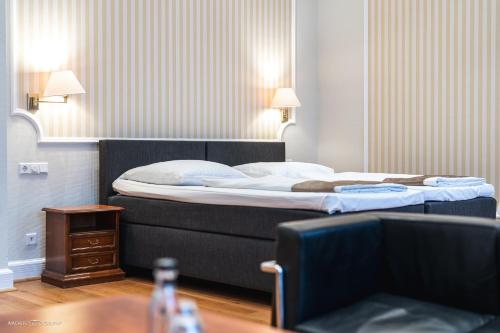 a bedroom with a large bed and a table at Schlosshotel Westerholt in Herten
