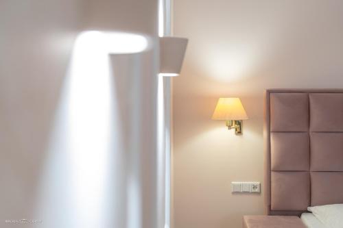 a bedroom with a bed and a lamp on the wall at Schlosshotel Westerholt in Herten
