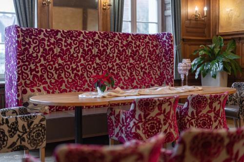 a table and chairs with a red and white couch at Schlosshotel Westerholt in Herten