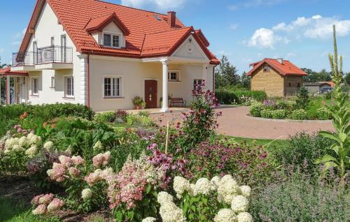 a house with a garden with flowers in front of it at Amazing Home In Silec With Sauna in Srokowo