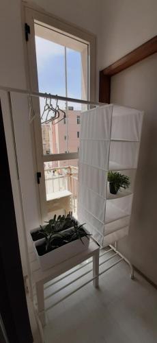 a room with a window and a table with plants at Retrò Rooms in Cefalù