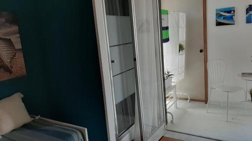 a glass cabinet in a room with a blue wall at Retrò Rooms in Cefalù