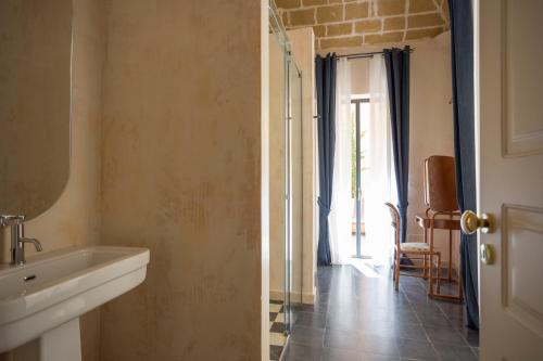 a bathroom with a sink and a glass door at Palazzo Presta in Gallipoli