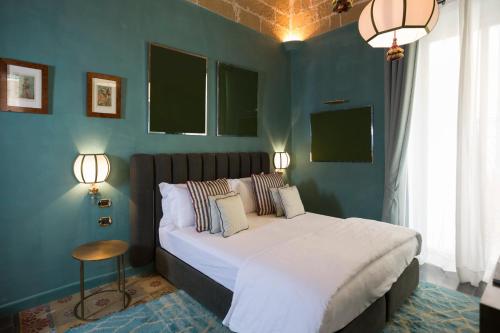 a bedroom with a large bed with blue walls at Palazzo Presta in Gallipoli