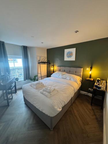a bedroom with a large bed with a green wall at The London Inn in Padstow