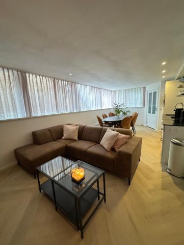 a living room with a brown couch and a table at Studioverhuur De Nieuwe Doelen in Zevenaar