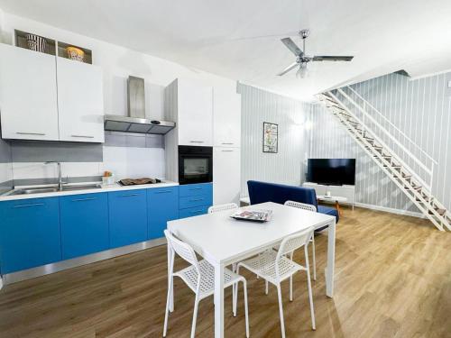 a kitchen with blue cabinets and a white table and chairs at Luxury Allegra’s home in Siracusa