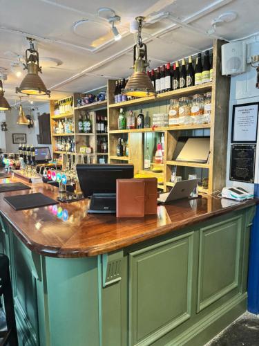 a bar with a laptop on a wooden counter at The London Inn in Padstow