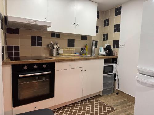a kitchen with white cabinets and a stove top oven at Casa da Barragem in Negrões