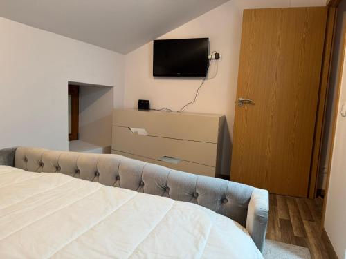 a bedroom with a bed and a flat screen tv at Casa da Barragem in Negrões