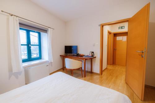 a bedroom with a desk and a bed and a window at Pri Žabarju Bed & Breakfast Ljubljana in Ljubljana